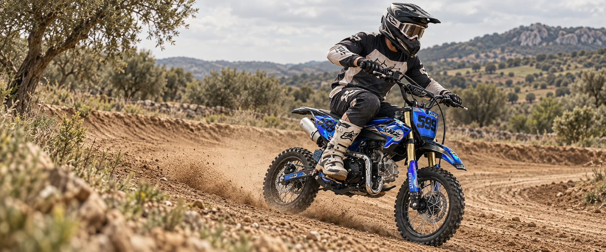 Piloto con equipación de motocross sobre una pit bike en una pista de tierra